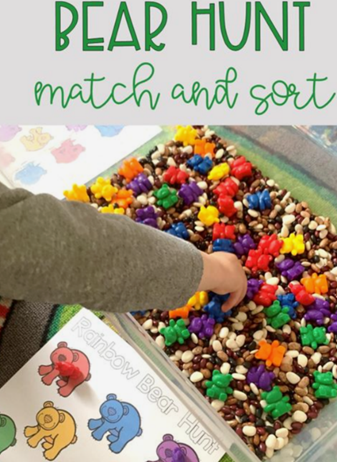 a hand reaches into a sensory bin with many colorful objects